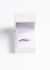 Anillo dorado de acero quirúrgico con piedra blanca engarzada.