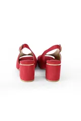 Zapato de cuero nobuck color rojo con detalles dorados, taco cuadrado de 7 cm y tira trasera con hebilla.