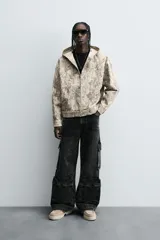 Pantalón relaxed fit de denim negro con efecto lavado, bolsillos frontales, traseros de plastrón y multifunción en perneras. Bajo ajustable con trabilla y cierre frontal con cremallera y botón.