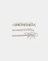 Set de tres horquillas plateadas para el pelo: una con moños de strass, otra con perlas y otra con un moño de strass.
