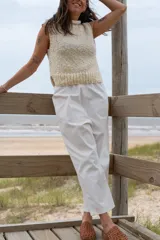 Chaleco tejido color crema, con cuello alto y sin mangas.