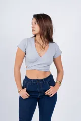 Remera corta color beige con escote en V y nudo frontal.