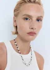 Top sin mangas color blanco, de tejido acanalado, con cuello halter y diseño entallado.