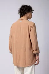 Camisa blanca de lino con cuello clásico, manga larga con puños abotonados y corte holgado. 