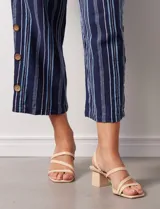 Pantalón capri de algodón estampado a rayas verticales en tonos celeste, rosa y beige. Tiene pretina elastizada, bolsillos delanteros y tajos laterales con botones.