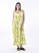 Vestido largo estampado, con tirantes anudados al hombro. El estampado es de formas orgánicas grandes en color verde lima y blanco. El vestido tiene un corte suelto y volados en el ruedo.