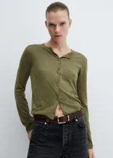 Cárdigan color crema de tejido de punto fino, corte recto, cuello redondo, manga larga, cierre frontal con botones y terminaciones en canalé.