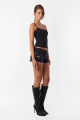 Short de jean negro con roturas, tiro medio, cintura con pasacintos, cierre y botón metálico.