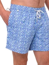 Short de baño celeste con estampado de ballenas en azul y gris. Tiene cintura elástica con cordón ajustable y bolsillos laterales.