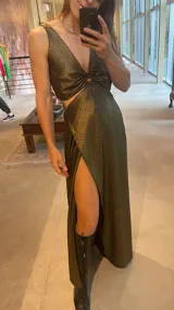 Vestido largo negro con lurex dorado, escote en V con aro y falda con capas diagonales.