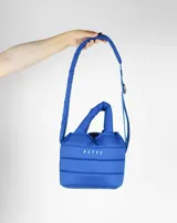Bolsito impermeable color azul con asas y correa ajustable.