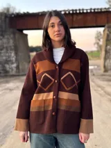 Campera marrón con diseño geométrico en tonos beige y marrón, con cuello tipo chal y cierre con botones.