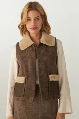 Chaleco corto marrón con estampado pata de gallo, cuello y bolsillos con ribete de piel sintética color beige.