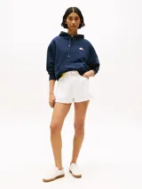 Buzo azul marino amplio con capucha y cordón distintivo, bolsillo canguro, puños y bajo de punto canalé, logo oversize de Tommy Hilfiger en la manga y la parte trasera, parche con logo de Tommy Hilfiger en el pecho y detalles distintivos de Hilfiger Sailing.
