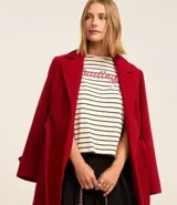 Remera boxy de algodón y poliéster a rayas horizontales blancas y negras, con cuello redondo y mangas cortas. Estampa frontal con la palabra "Darling" en color rojo.