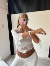 Remera blanca de manga larga, confeccionada en encaje floral, con escote en V.