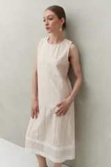 Vestido largo color beige, sin mangas, confeccionado en algodón con calados verticales y bordado tipo ojo de perdiz.
