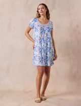 Camisón corto de tejido suave con estampado floral en tonos celeste y azul. Tiene mangas cortas, escote redondo con ribete gris y detalle plisado en el delantero.