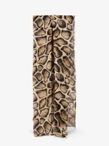 Bufanda rectangular con estampado de manchas tipo animal print en tonos marrón, beige y negro. Tiene flecos pequeños en los extremos.