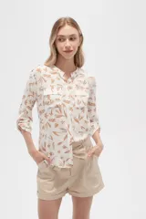Camisa de viscosa con estampado floral en tonos azul, beige y blanco. Tiene cuello mao, mangas largas y bolsillos en el pecho.