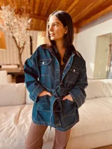 Campera tipo trench de jean con corte oversized y cinturón. Presenta espalda y cuello de cuero ovino.