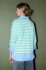 Remera de algodón blanca con rayas horizontales verdes, cuello redondo y logo bordado en azul en el pecho.