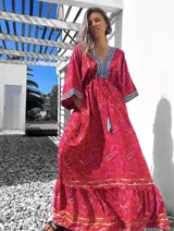 Vestido largo tipo túnica con estampado paisley en tonos rojos y detalles bordados en azul en escote y mangas.