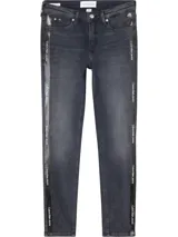 Jeans skinny de tiro medio color gris oscuro, con cierre de cremallera y botón, bolsillos delanteros y traseros, y banda lateral con logo de Calvin Klein Jeans.