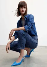 Pantalón de jean azul oscuro, de tiro alto, corte mom fit y largo a la altura del tobillo.