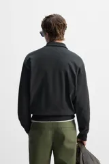 Sudadera negra de algodón con cuello polo y cierre de cremallera.
