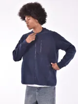 Campera bomber de micropolar azul marino con cierre frontal, cuello redondo y bolsillo vertical con cierre en el pecho.