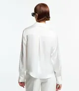 Camisa blanca de satén con cuello inglés, manga larga y cierre frontal con botones.