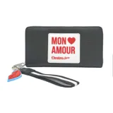 Billetera negra con cierre de cremallera, textura granulada y parche blanco con la frase 'Mon Amour' en rojo y el logo de Las Oreiro. Incluye correa de muñeca con diseño a rayas y charm con forma de labios.