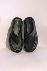 Sandalias negras de cuero sintético con plataforma y diseño minimalista.