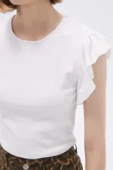 Remera blanca de algodón con cuello redondo, corte al cuerpo y mangas cortas con volados.