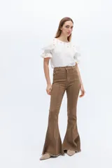 Pantalón jean acampanado color marrón con alforza central y ruedo desflecado.
