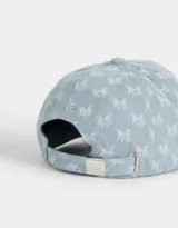 Gorra de jean celeste con estampado de mariposas blancas, visera curva y tira ajustable en la parte trasera.