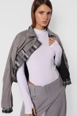Body blanco de algodón con lycra, de manga larga con detalle de mitón en los puños y cuello media polera.