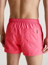Short de baño corto color rosado con cintura elástica ajustable con cordón blanco y logo CK plateado estampado en la pierna derecha.
