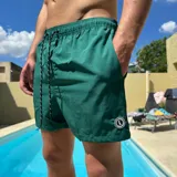 Short de baño verde esmeralda con cintura elástica y cordón ajustable.