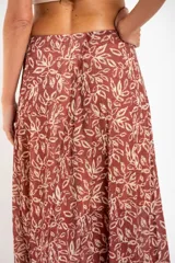 Falda larga de poliéster color terracota con estampado de hojas en color crema.
