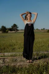 Conjunto de top y pantalón color beige. El top es de breteles anchos, con escote cuadrado y detalle de bordado en el frente. El pantalón es de corte recto y ancho, con bolsillos laterales y cintura con elástico y botones.