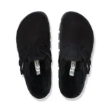 Zueco color negro con forro de pelaje, hebilla lateral y suela gruesa.