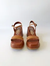 Sandalias de cuero color marrón con plataforma y pulsera al tobillo.