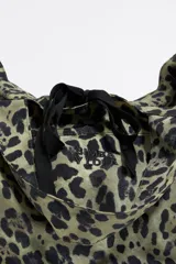 Bolso shopper de nylon con estampado animal print en tonos verde y negro. Tiene doble asa de mano, asa de tejido, bolsillo interior y etiqueta cerillera.