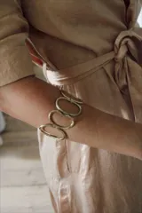 Pulsera rígida dorada con diseño de eslabones ovalados.