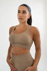 Top deportivo gris con breteles anchos y espalda deportiva.