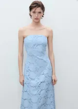 Vestido midi celeste con bordado inglés, palabra de honor y diseño evasé. Incluye tiras de silicona interiores para mayor sujeción y cierre de cremallera en la parte posterior. Con forro interior.