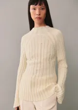Sweater de punto color crema con cuello perkins y diseño de canalé vertical con aberturas.