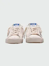 Championes Golden Goose modelo Super Star, de cuero color blanco con detalles en gris, cordones y suela desgastada. Presentan una estrella gris en el lateral y el logo GGDB en la lengüeta.
